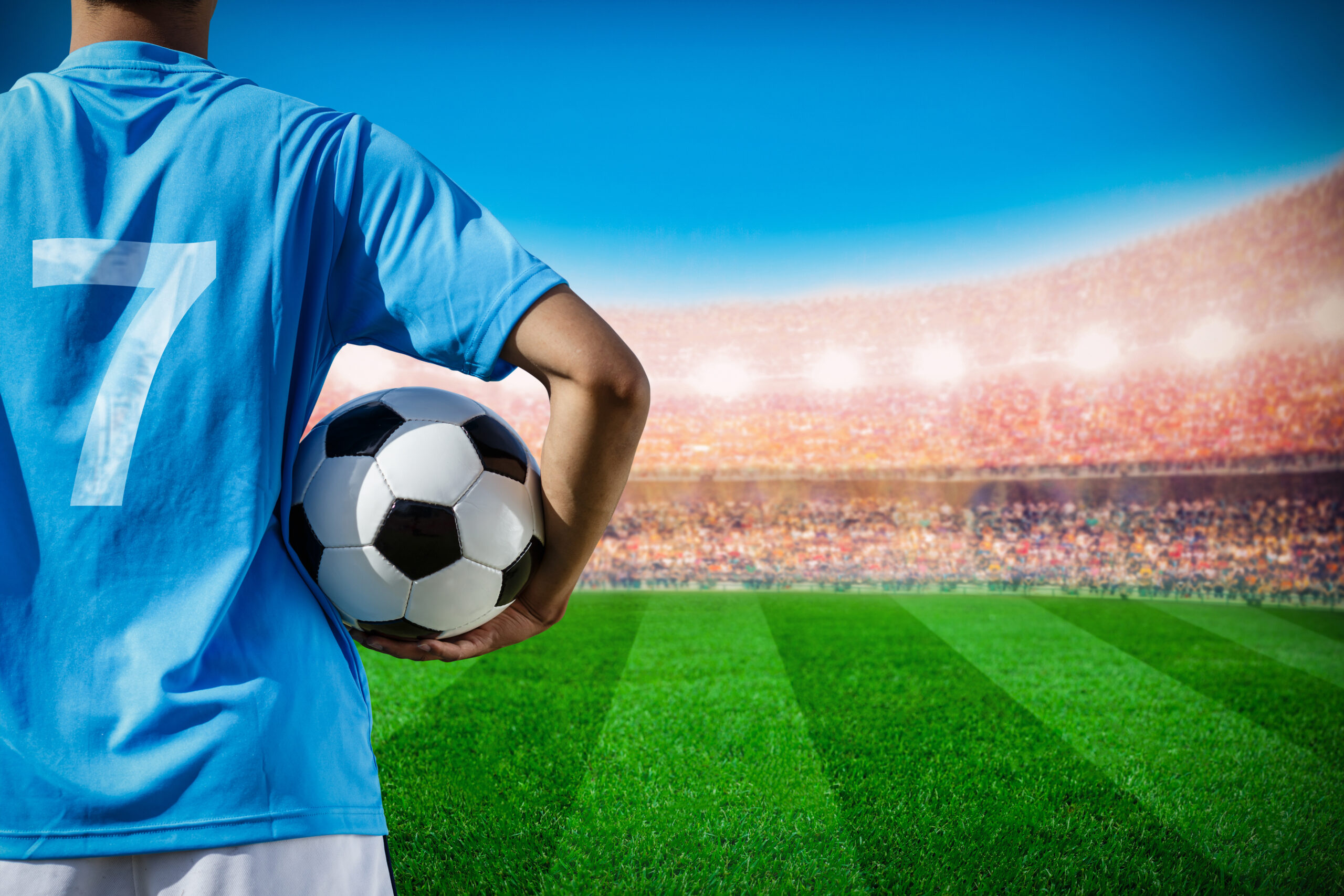 soccer football player no.7 in blue team concept holding soccer ball in the stadium